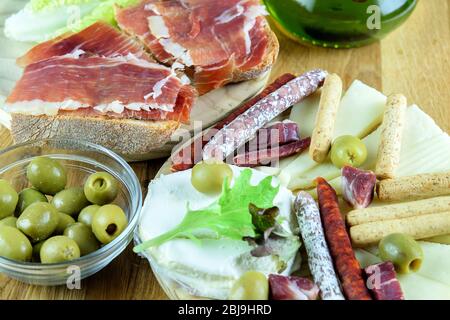 Sandwiches mit Jamon, grüne Olivesin einer Glasschüssel. Fuet Wurst, Chorizo Wurst, Käse und Brotsticks auf dem Holzteller. Mittelmeer schnell f Stockfoto