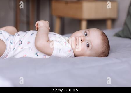 Porträt von niedlichen kleinen Mädchen liegt auf dem Bett im Schlafzimmer zu Hause. Konzept der glücklichen Kindheit Stockfoto