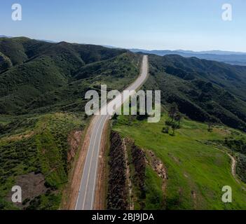 Zweispurige Asphaltstraße durch die niedrigen Hügel von Südkalifornien außerhalb von Santa Clarita. Stockfoto