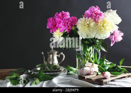 Komposition mit schönen Pfingstrosen auf dunklem Hintergrund Stockfoto