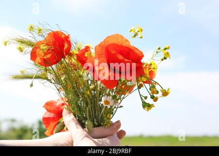 Mädchen mit frischen Wildblumen-Bouquet im Feld Stockfoto