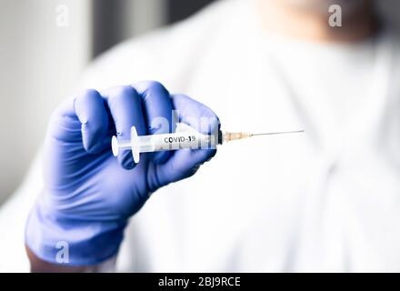 Arzt mit Coronavirus Impfnadel. Covid 19 Shot Konzept. Forschung zur Virusimmunität im Labor. Krankenschwester mit Handschuhen im Krankenhaus. Einspritzanlagen. Stockfoto
