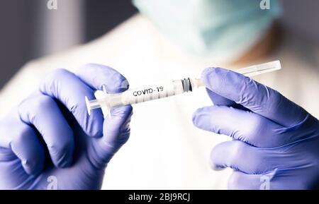 Covid 19 Impfstoff, Immunität und medizinische Behandlung Konzept. Coronavirus Spritze und Nadel. Arzt oder Krankenschwester, die im Gesundheitswesen arbeitet und eine Maske trägt. Stockfoto
