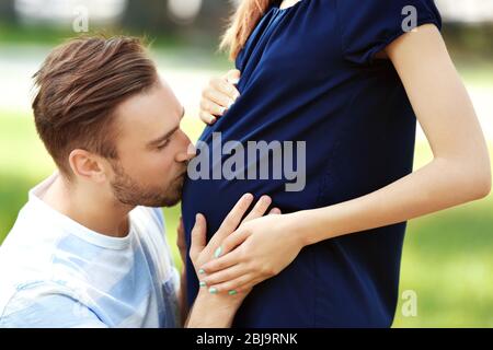 Ehemann küssen Frau Baby Beule auf Natur Hintergrund, Nahaufnahme Stockfoto