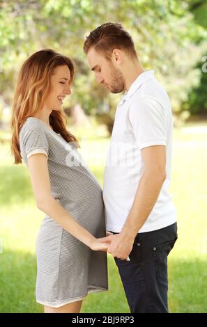 Schwangere Frau und ihr Mann im Park Stockfoto