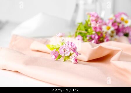 Schöner Strauß Wiesenblumen auf rosa Serviette Stockfoto