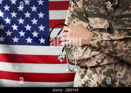 Armee Arzt hält Stethoskop auf amerikanischer Flagge Hintergrund Stockfoto