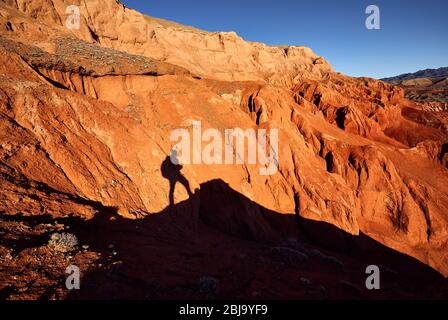 Touristische Schatten am roten Berge in der Wüste Canyon gegen den blauen Himmel in Kasachstan Stockfoto