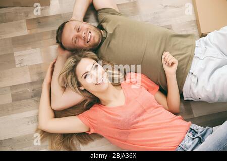 Schönes Paar auf Holzboden liegend Stockfoto