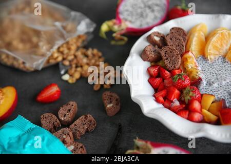 Gesundes Frühstück mit Chia Samen und Früchte in Teller auf grauem Hintergrund Stockfoto