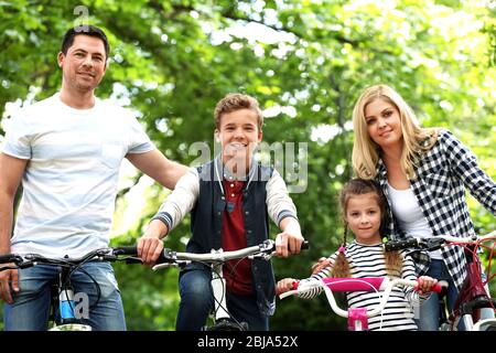 Glückliche Familie mit Fahrrädern im Park Stockfoto