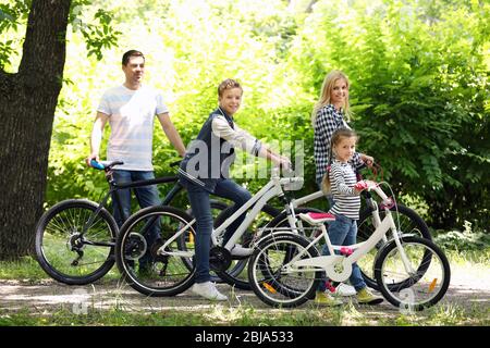 Glückliche Familie mit Fahrrädern im Park Stockfoto