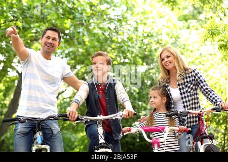 Glückliche Familie mit Fahrrädern im Park Stockfoto