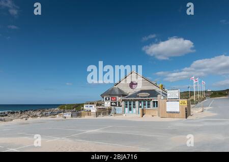 Ein verlassene Parkplatz und geschlossene Restaurants und Surfverleihe im Fistral in Newquay. Das Ergebnis der Covid 19 Coronavirus Einschränkungen. Stockfoto