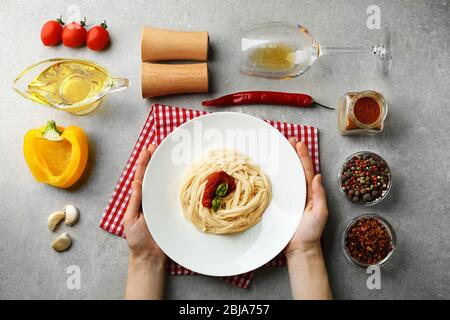 Zusammensetzung der Spaghetti in weißer Platte auf grauem Hintergrund Stockfoto