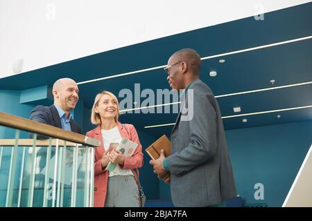 Erfolgreiche Geschäftskollegen treffen sich im Büro und sprechen miteinander Stockfoto