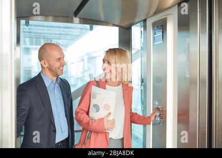 Geschäftstreffen für Paare im Aufzug eines modernen Bürogebäudes Stockfoto