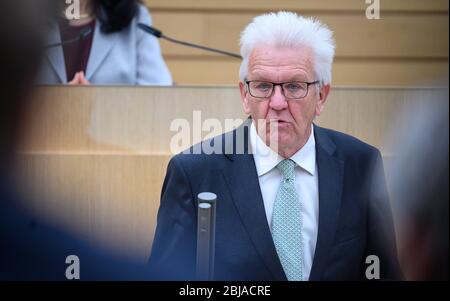 Stuttgart, Deutschland. April 2020. Der Ministerpräsident von Baden-Württemberg, Winfried Kretschmann (Bündnis 90/die Grünen, l), spricht in seiner Regierungserklärung zum Umgang mit der Corona-Pandemie in der 117. Sitzung des 16. landtags Baden-Württembergs. Quelle: Sebastian Gollnow/dpa/Alamy Live News Stockfoto