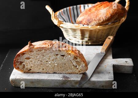 Startseite Kochen hausgemachte Bio-Sauerteig Brot auf schwarzem Hintergrund mit Kopierraum Stockfoto