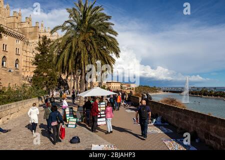 Palma, Mallorca - 10. April 2019: Afrikanische Straßenhändler versuchen, Piraterie auf Touristen in der Nähe der Kathedrale de Palama zu verstauen. Stockfoto