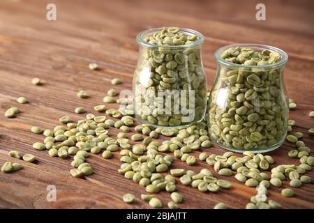 Kaffeesorten in Gläsern auf Holztisch Stockfoto