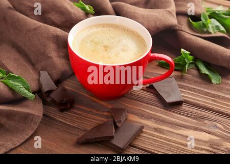 Tasse Kaffee mit Schokoladenstücken auf dem Tisch Stockfoto