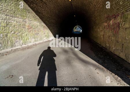 Schatten einer Person, eines Menschen, am Anfang eines Tunnels, symbolisches Bild, Stockfoto