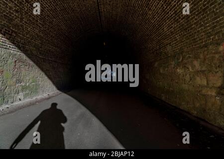 Schatten einer Person, eines Menschen, am Anfang eines Tunnels, symbolisches Bild, Stockfoto