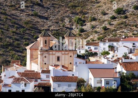 Blick auf das weiß getünchte Dorf (Pueblo Blanco) mit Bergen im Hintergrund, Alpandeire, Serrania de Ronda, Provinz Málaga, Andalusien, Spanien. Stockfoto