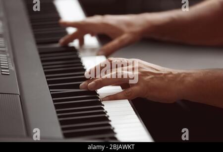 Männliche Hände spielen auf Synthesizer Stockfoto