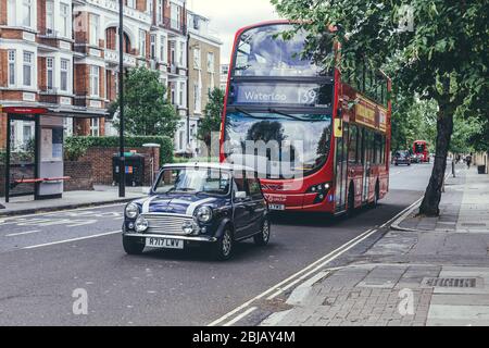 London/UK-30/7/18: Der purpurne Mini cooper und der Routemaster auf der Abbey Road in der City of Westminster. Der rote Doppeldeckerbus und Mini Cooper beides Stockfoto