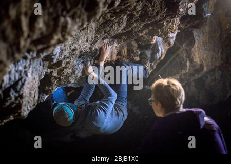 Der Mensch macht einen Felsbrocken in der Twardowski Höhle. Bouldern im Fels. Twardowski Höhle Stockfoto