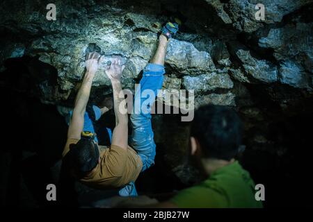 Der Mensch macht einen Felsbrocken in der Twardowski Höhle. Bouldern im Fels. Twardowski Höhle Stockfoto