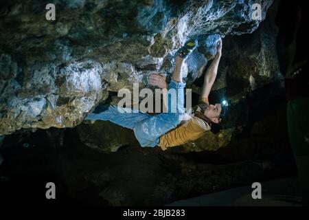Der Mensch macht einen Felsbrocken in der Twardowski Höhle. Bouldern im Fels. Twardowski Höhle Stockfoto