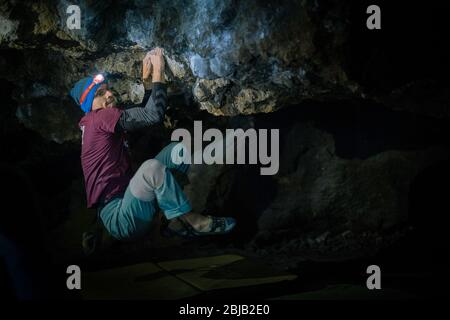 Der Mensch macht einen Felsbrocken in der Twardowski Höhle. Bouldern im Fels. Twardowski Höhle Stockfoto