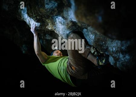 Der Mensch macht einen Felsbrocken in der Twardowski Höhle. Bouldern im Fels. Twardowski Höhle Stockfoto