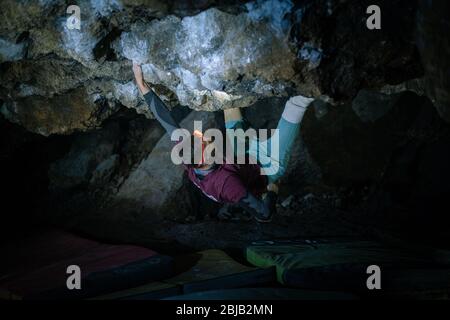 Der Mensch macht einen Felsbrocken in der Twardowski Höhle. Bouldern im Fels. Twardowski Höhle Stockfoto