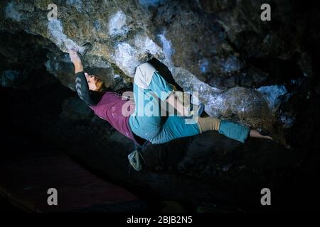 Der Mensch macht einen Felsbrocken in der Twardowski Höhle. Bouldern im Fels. Twardowski Höhle Stockfoto