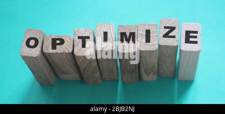 Optimieren Wort auf Holzblöcke mit Buchstaben, Suchmaschinen-Optimierung SEO-Konzept, Draufsicht auf cyanfarbenem Hintergrund Stockfoto