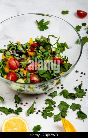 Gesunde Ernährung Lebensmittel. Fitness-Salat aus verschiedenen frischen Grüns, Tomaten, Paprika, Avocados, Gurken mit Olivenöl und Balsamico-Sauce Stockfoto