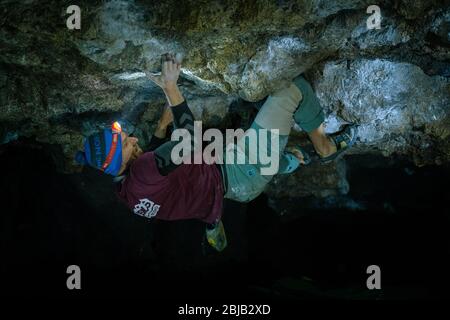 Der Mensch macht einen Felsbrocken in der Twardowski Höhle. Bouldern im Fels. Twardowski Höhle Stockfoto