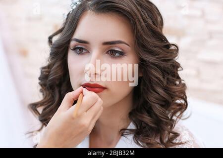 Make-up-Künstlerin Vorbereitung Braut vor ihrer Hochzeit Stockfoto
