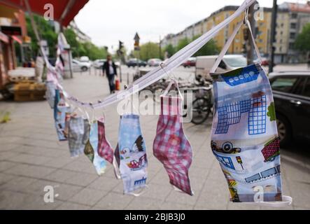 Berlin, Deutschland. April 2020. Selbstgenähte Masken als Mund- und Nasenschutz hängen in einer großen Auswahl und verschiedenen Mustern vor einer Schneiderei in der Danziger Straße im Prenzlauer Berg. In Deutschland sind Masken im öffentlichen Verkehr und in Geschäften obligatorisch. Quelle: Jens Kalaene/dpa-Zentralbild/dpa/Alamy Live News Stockfoto