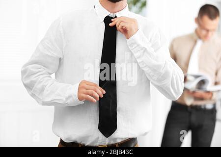 Mann Anpassung Lederband im Büro Stockfoto