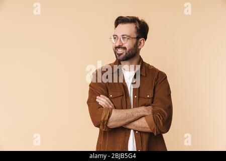Porträt eines fröhlichen jungen kunsttraktiven bärtigen Mannes, Arme gefaltet Stockfoto
