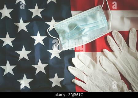 Coronavirus, amerikanische Flagge mit medizinischer Maske und medizinischen Handschuhen, Hintergrund Stockfoto