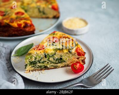 Zucchini Kuchen und Zutaten auf grauem Hintergrund, kopieren. Stück leckere herzhafte Kuchen mit Zucchini, Tomaten, Kräuter und Käse. Idee und Rezept für gesundes Backen und viel zu Ernten von Zucchini Stockfoto