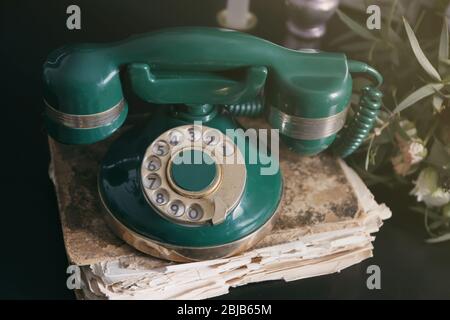 Altes Telefon und Telefonbuch auf Tisch, Nahaufnahme Stockfoto