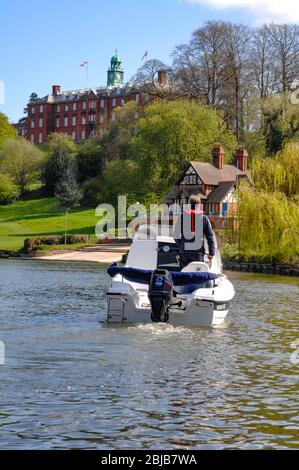 Motorboot auf dem Fluss, vorbei am Pengwern Boat Club und Shrewsbury School am Fluss Severn in Shrewsbury. Stockfoto