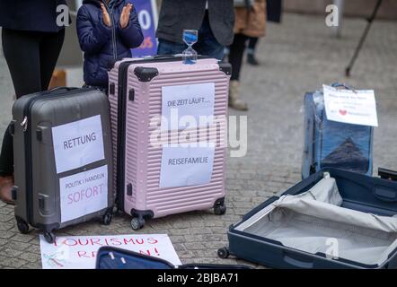 Schwerin, Deutschland. April 2020. Mit leeren Koffern stehen Besitzer und Mitarbeiter von Reisebüros während einer Protestaktion vor der Staatskanzlei. Angesichts der niedrigen Infektionsraten in Mecklenburg-Vorpommern fordern Reiseexperten eine Normalisierung in der Koronakrise. Bis zu 50 Vertreter von Reiseveranstaltern nutzen die Aktion, um auf ihre schwierige wirtschaftliche Situation aufmerksam zu machen. Aufgrund der aktuellen Corona-Entfernungsregeln sind keine weiteren Teilnehmer erlaubt. Quelle: Jens Büttner/dpa-Zentralbild/dpa/Alamy Live News Stockfoto